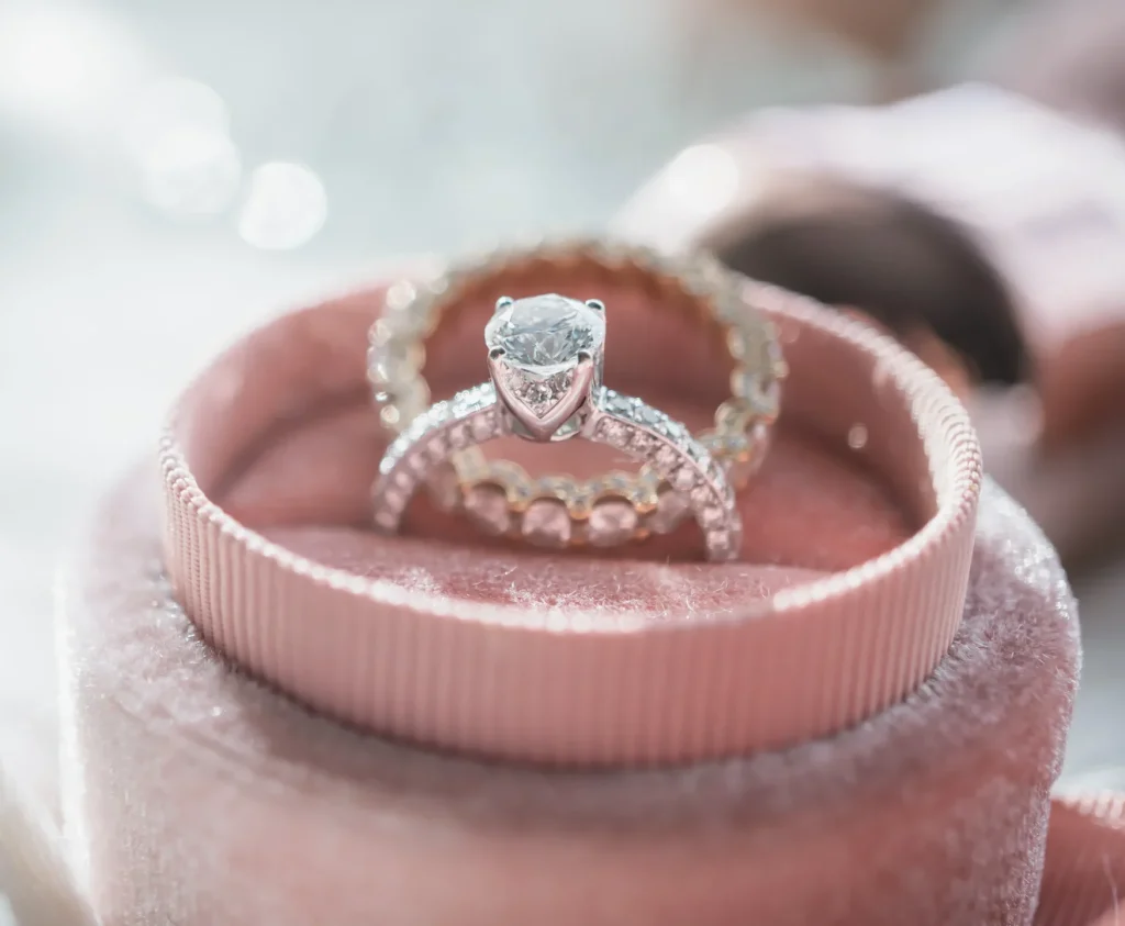 A close-up of a diamond bridal ring set in a luxurious pink velvet ring box
