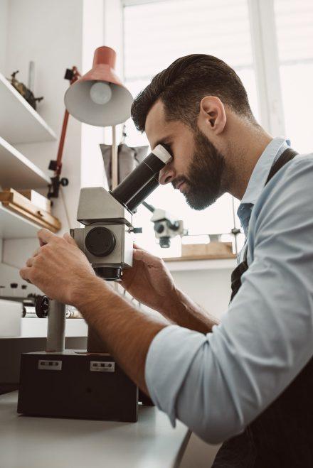 Jewelry Repair Services, a bench jeweler uses a microscope for expert precision in jewelry repairs